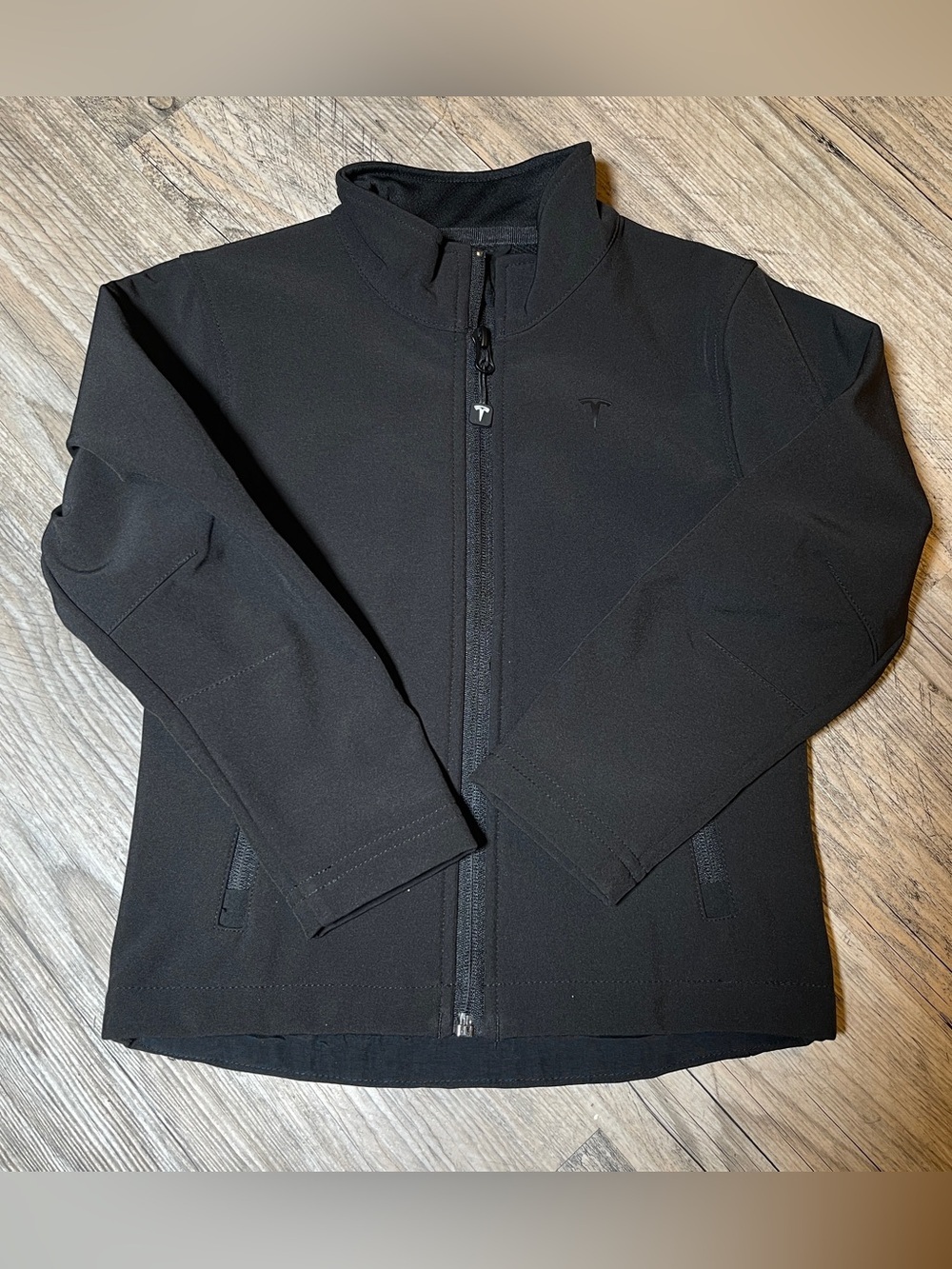 TESLA -The image features a Tesla Kids Corporate Softshell Jacket, black